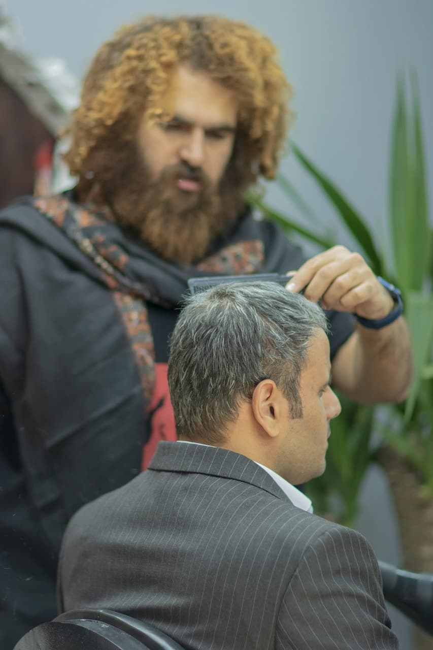 Combing through grey hair before a scissor cut