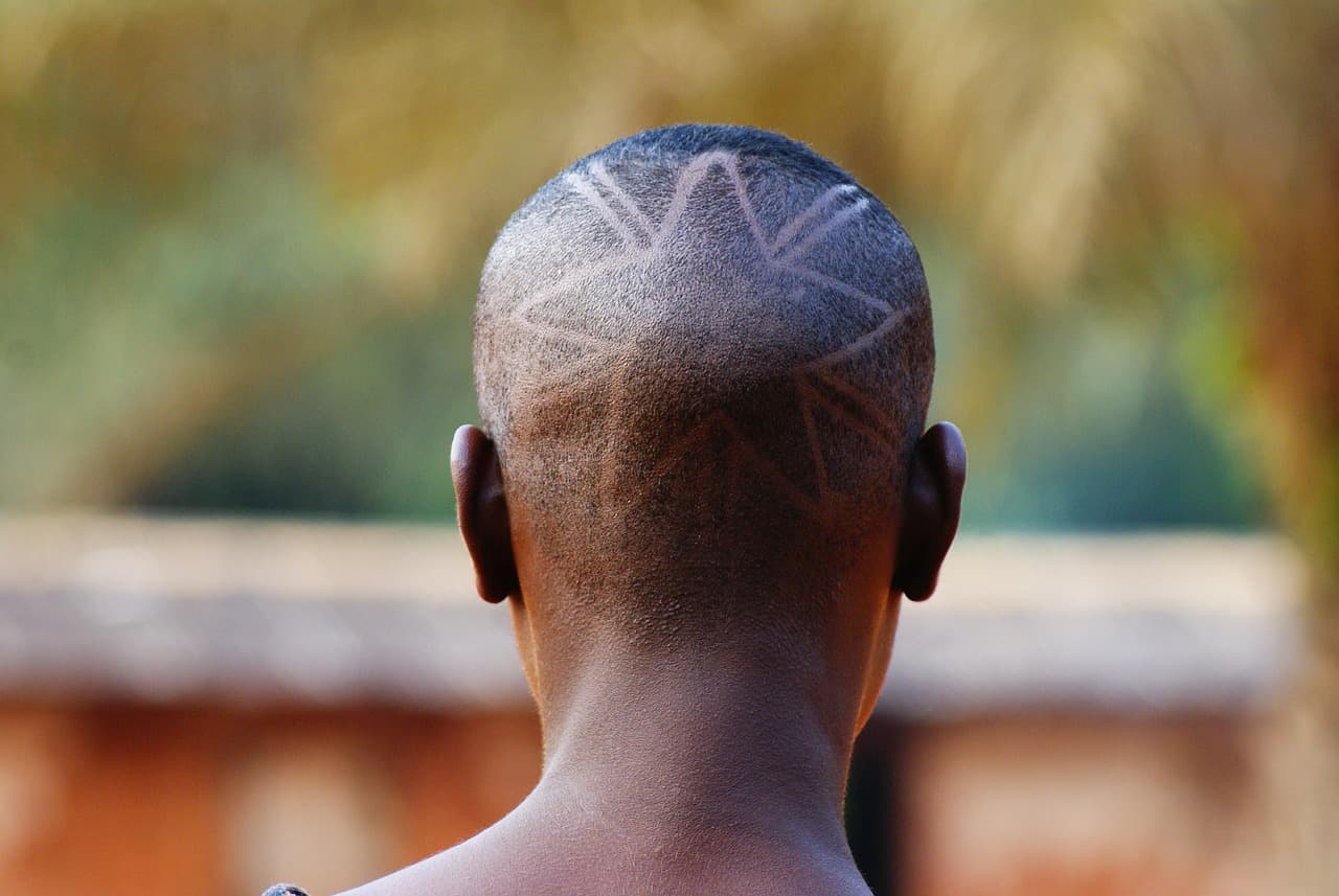 A short fade on afro hair with a cut-in design